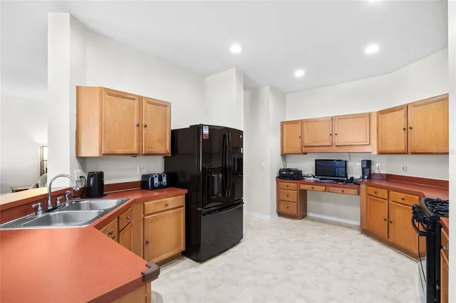 a kitchen with a refrigerator stove top oven a sink and dishwasher