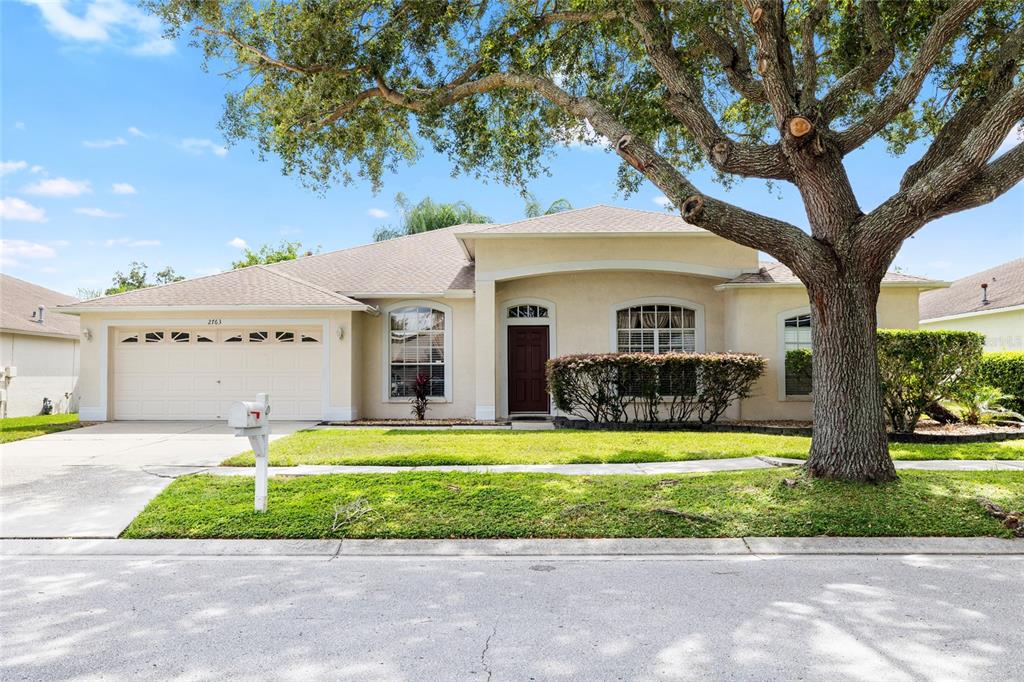 2763 Valencia Grove Drive Valrico, FL 33596 - Photo 2 of 38 a front view of a house with a yard and potted plants