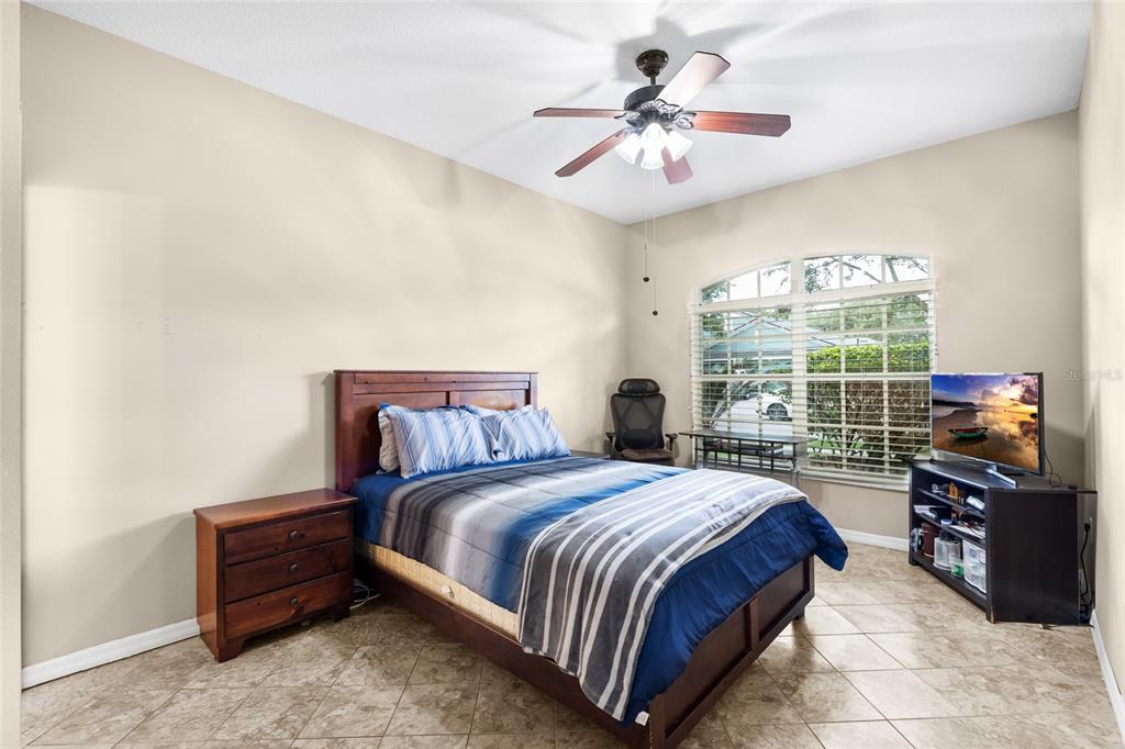 2763 Valencia Grove Drive Valrico, FL 33596 - Photo 25 of 38 a spacious bedroom with a bed and a chandelier