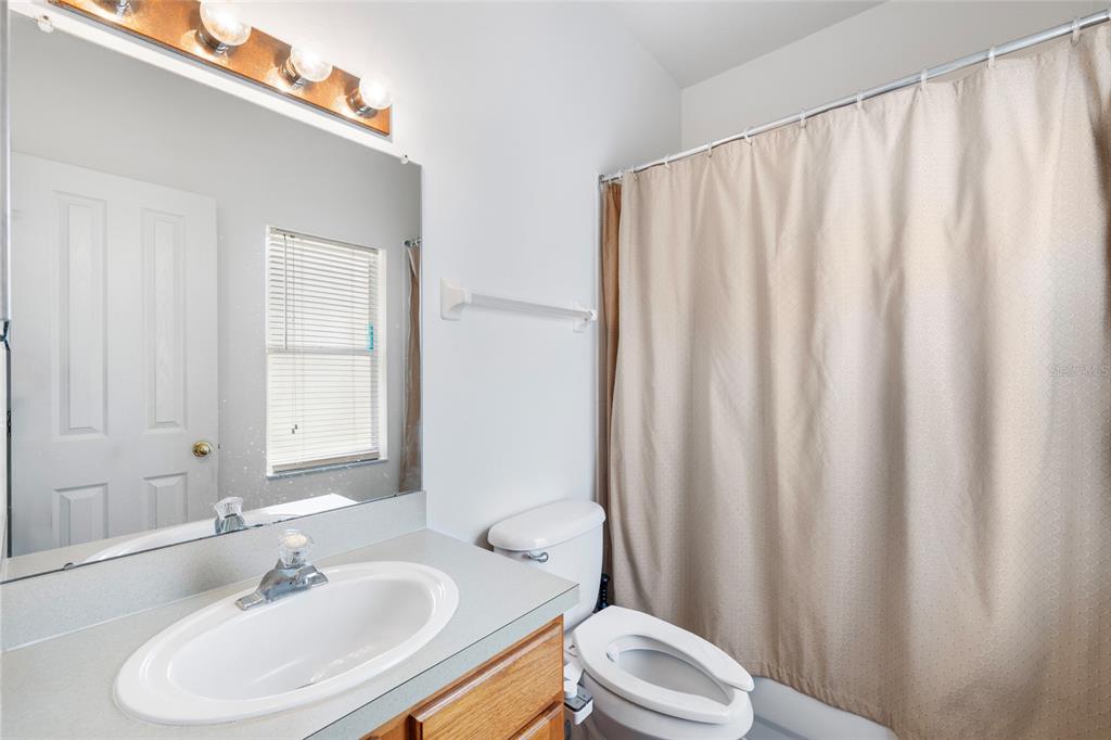2763 Valencia Grove Drive Valrico, FL 33596 - Photo 27 of 38 a bathroom with a sink a toilet and shower curtain