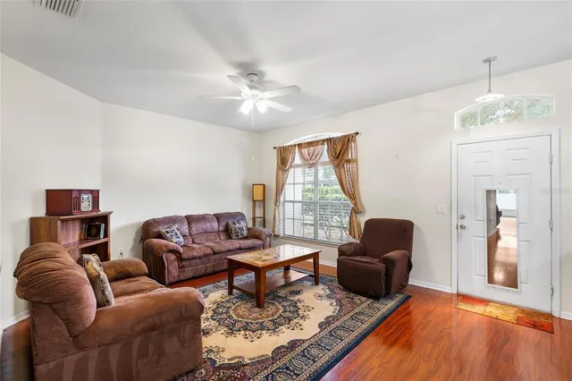 a living room with furniture ceiling fan and a window
