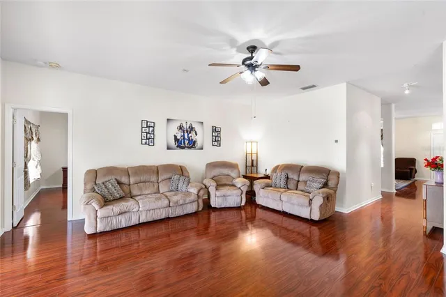 a living room with couches and a view of kitchen