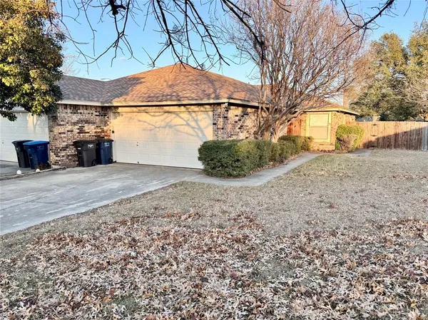 a view of a yard with a house and a large tree