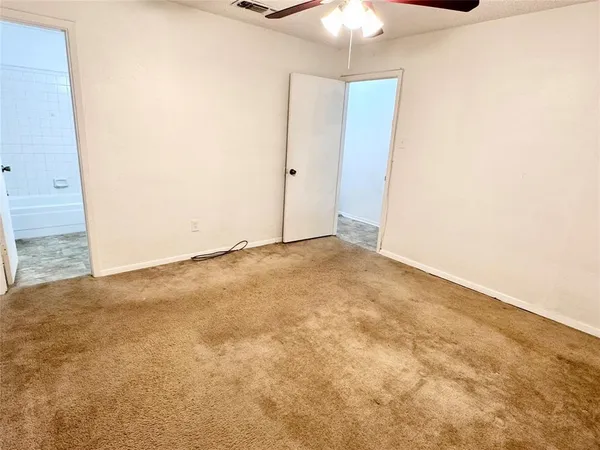 an empty room with a chandelier fan