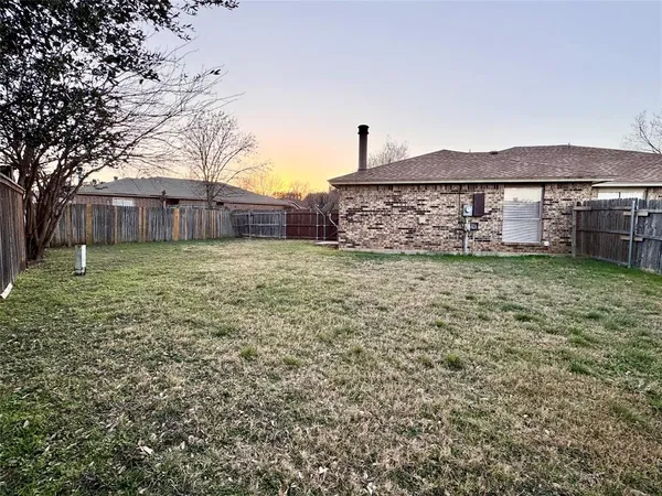 a view of a house with a yard and a large tree