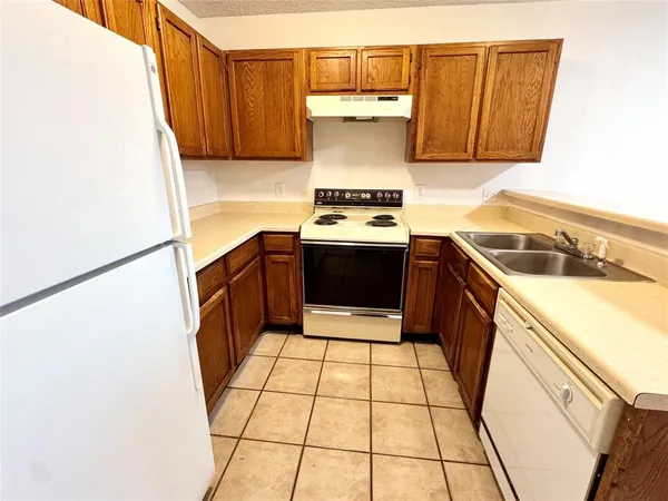 a kitchen with a stove a refrigerator and cabinets