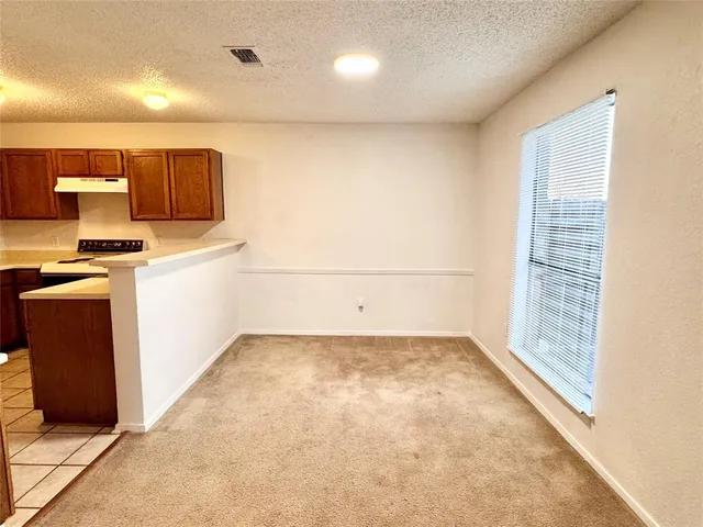 a view of a kitchen with wooden cabinets and a stove top oven