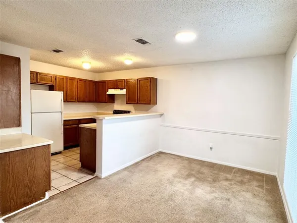 a view of kitchen with cabinets and refrigerator