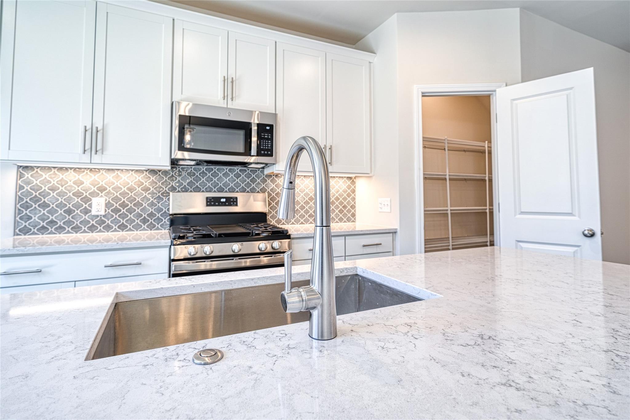 513 Madison Falls Court Fort Mill, SC 29708 - Photo 19 of 37 a kitchen with granite countertop a stove and a sink with granite countertops