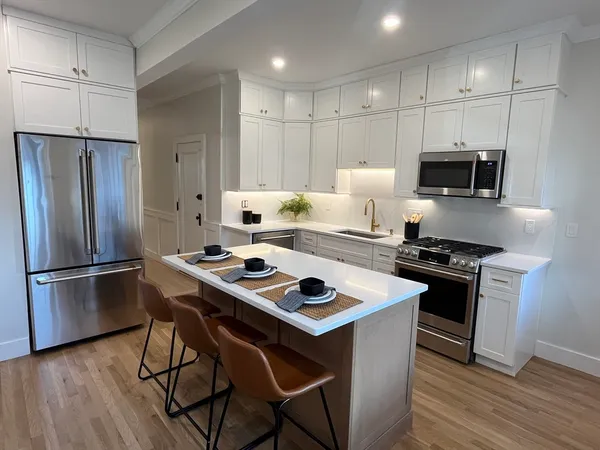 a kitchen with stainless steel appliances a stove a sink refrigerator and a microwave