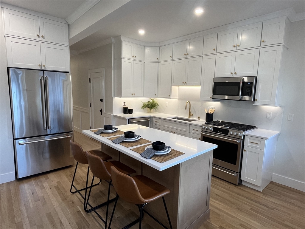 108 St Paul Street, Unit 2 Brookline, MA 02446 - Photo 1 of 15 a kitchen with stainless steel appliances a stove a sink refrigerator and a microwave