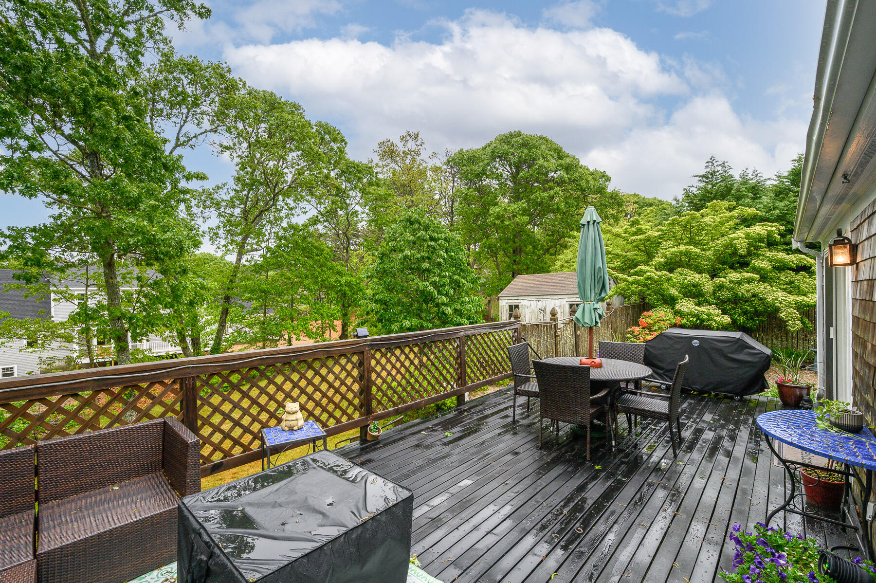 20 Squirrel Run Eastham, MA 02642 - Photo 31 of 37 a balcony with wooden floor outdoor seating and trees in the background