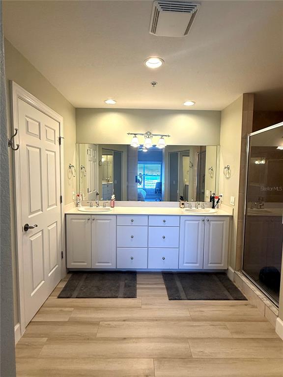 423 150th Avenue, Unit 1405 Madeira Beach, FL 33708 - Photo 14 of 23 a large bathroom with a granite countertop double vanity sink a mirror and a bathtub