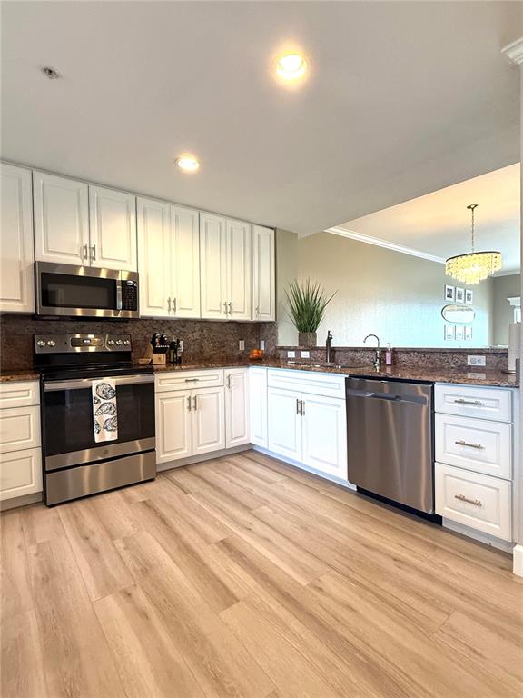 423 150th Avenue, Unit 1405 Madeira Beach, FL 33708 - Photo 3 of 23 a large kitchen with stainless steel appliances granite countertop a stove and a sink