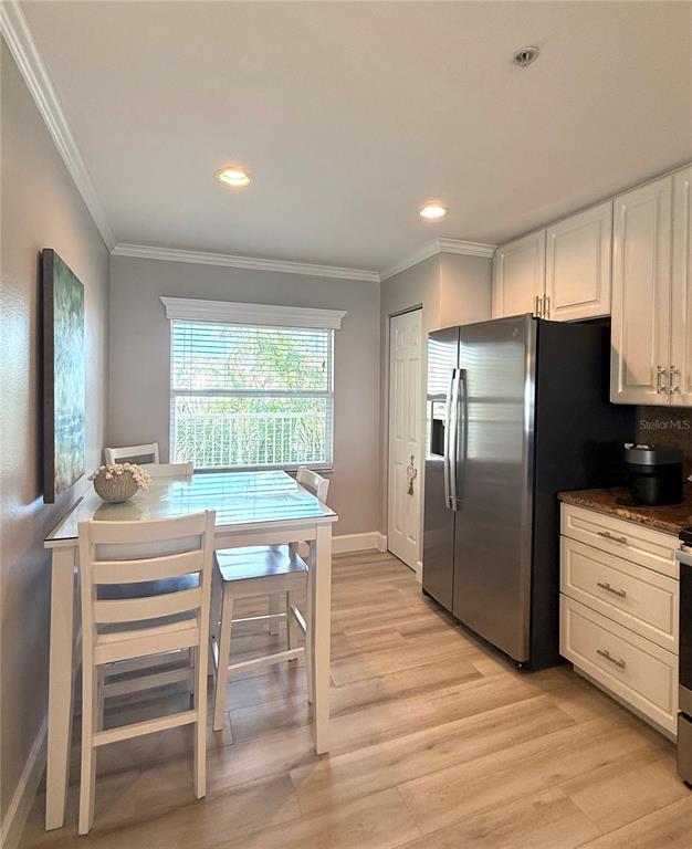 423 150th Avenue, Unit 1405 Madeira Beach, FL 33708 - Photo 4 of 23 a kitchen with a table chairs refrigerator and cabinets