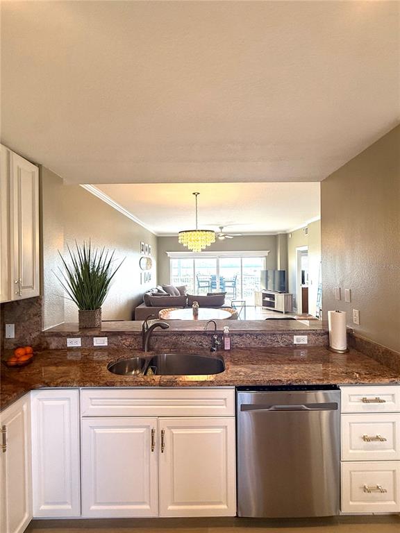 423 150th Avenue, Unit 1405 Madeira Beach, FL 33708 - Photo 5 of 23 a kitchen with stainless steel appliances granite countertop a sink and a white cabinets
