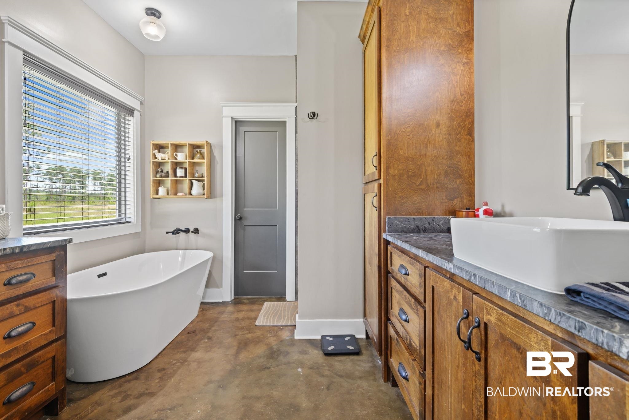 11025 Creax Road Axis, AL 36505 - Photo 24 of 45 Freestanding soaking tub with wall-mounted faucet, complemented by a distressed concrete-finish floor