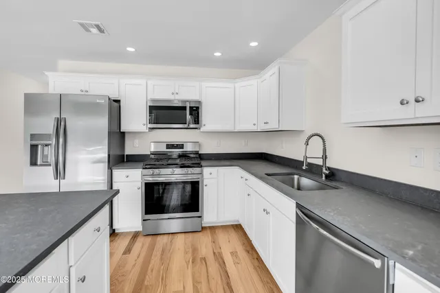 a kitchen with stainless steel appliances granite countertop a stove a sink and a refrigerator