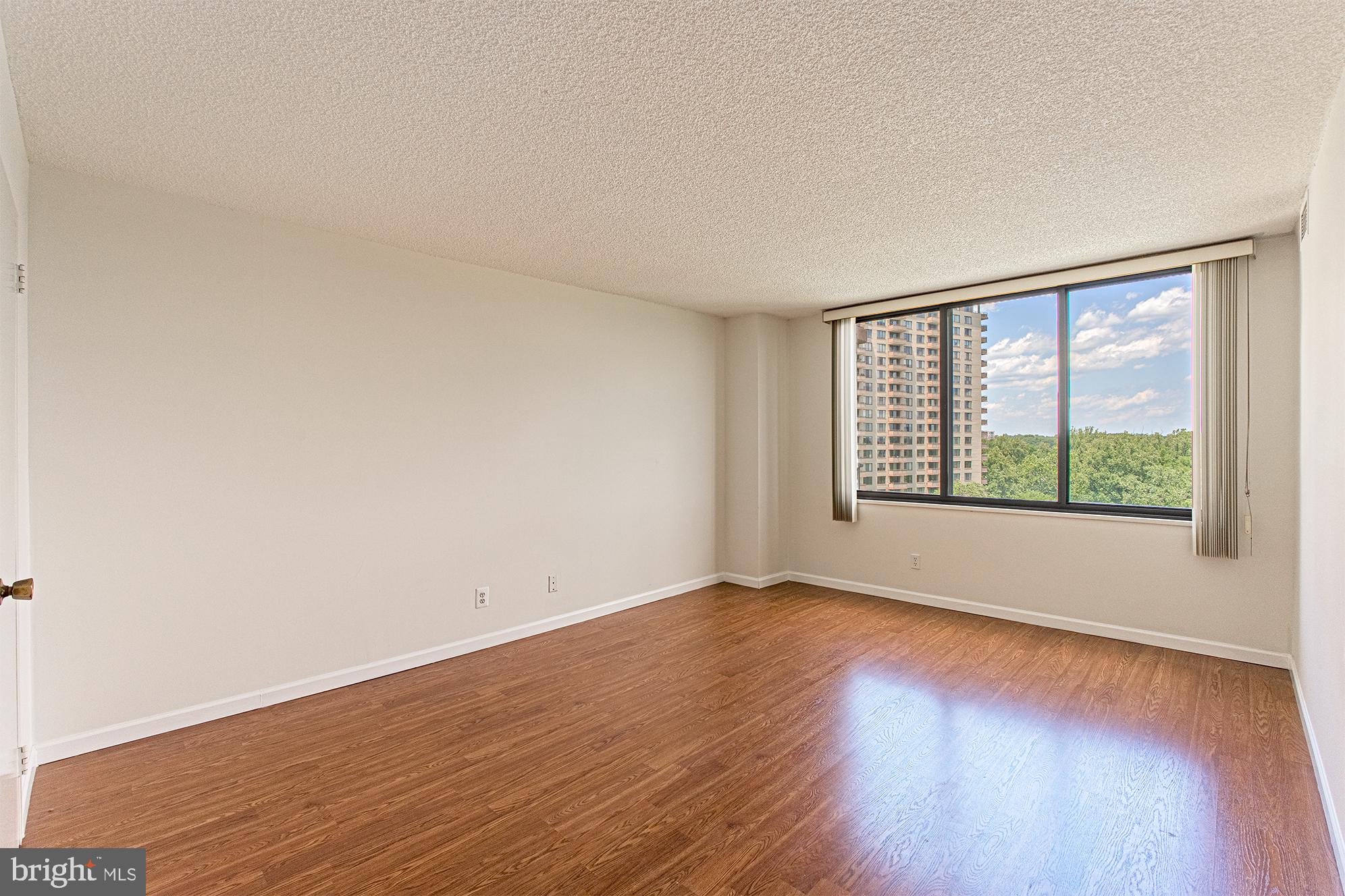 5225 Pooks Hill Road, Unit 721S Bethesda, MD 20814 - Photo 13 of 22 a view of an empty room with wooden floor and a window
