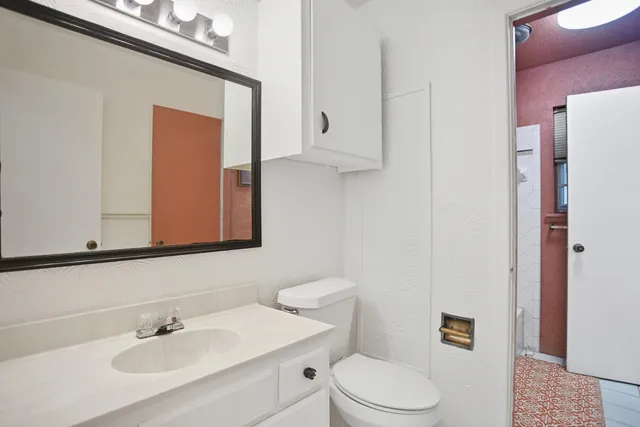 a bathroom with a sink a toilet and mirror