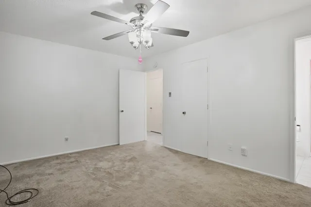 an empty room with a chandelier fan