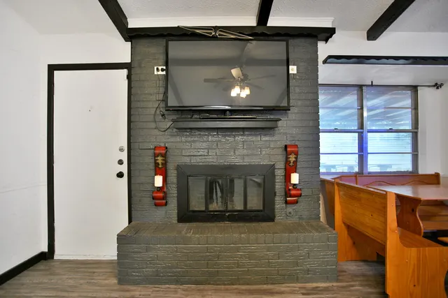 a living room with a fireplace and a wooden floor