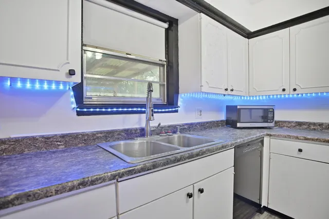 a kitchen with granite countertop a sink and cabinets