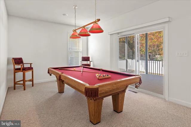 a room with pool table and windows