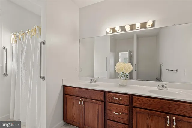 a bathroom with double vanity sinks and a mirror