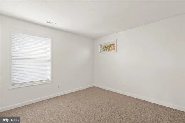an empty room with windows and couch