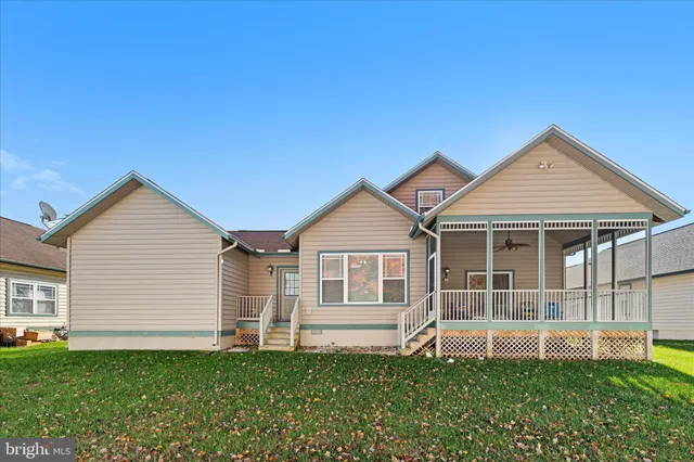 a view of an house with backyard space and a tree