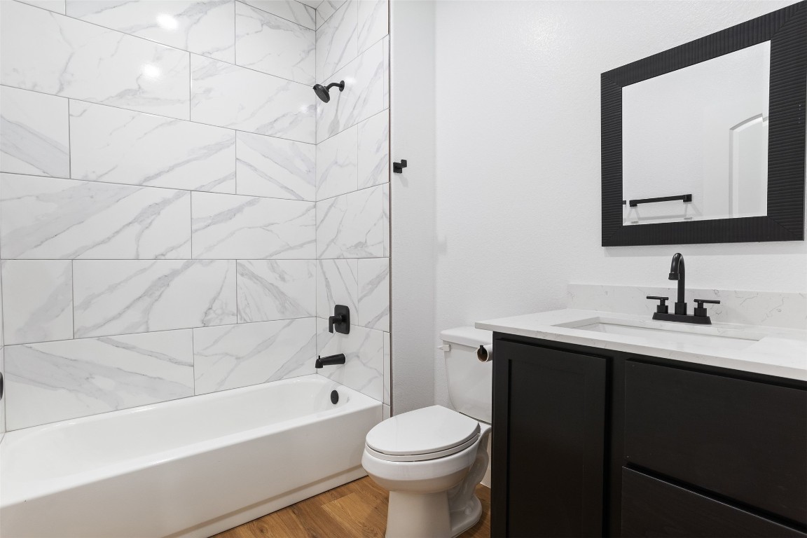 14390 Half Circle Splendora, TX 77372 - Photo 18 of 27 a bathroom with a toilet a sink a mirror a bathtub and vanity