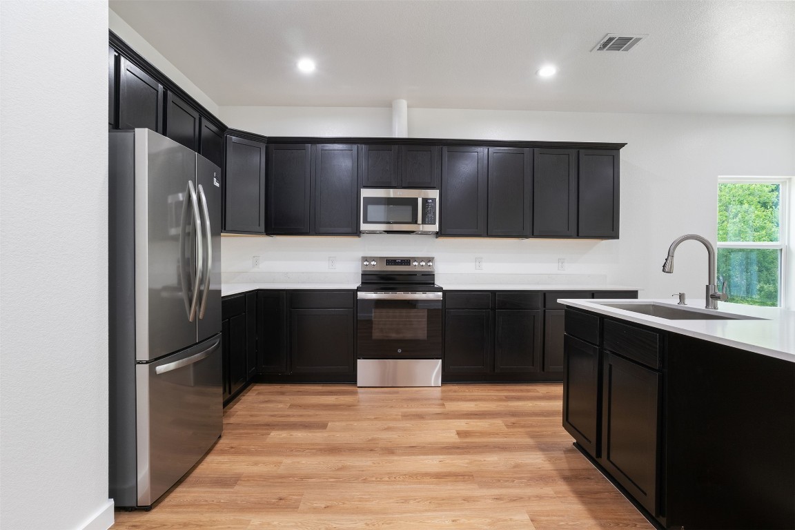 14390 Half Circle Splendora, TX 77372 - Photo 22 of 27 a kitchen with granite countertop a refrigerator and a sink