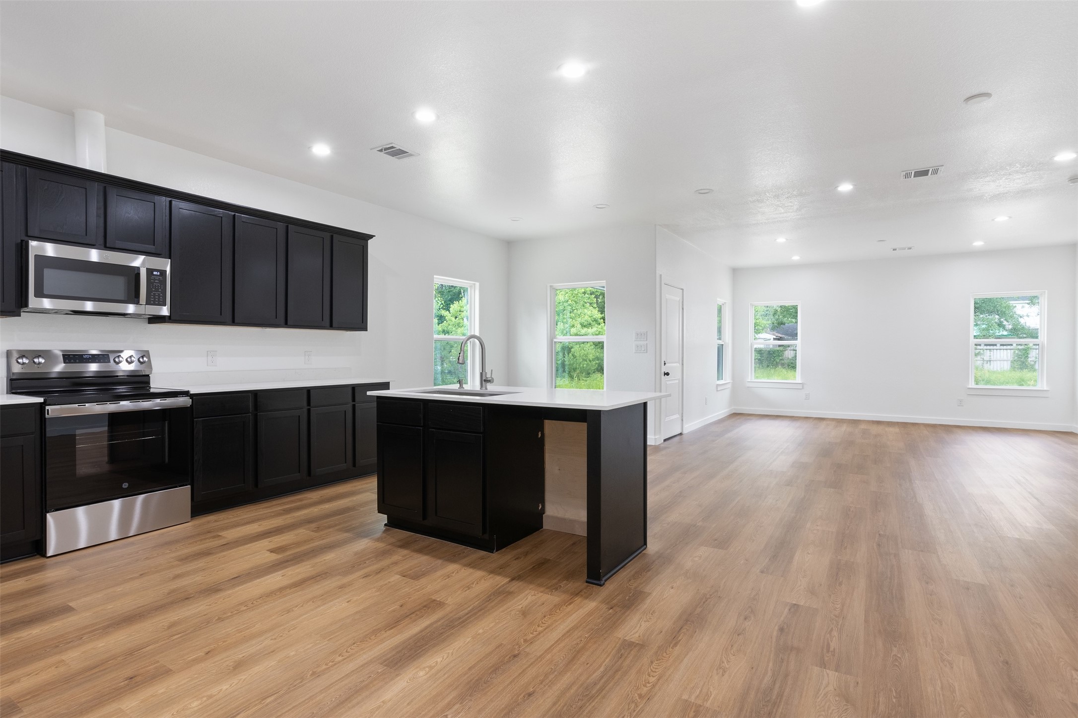 14390 Half Circle Splendora, TX 77372 - Photo 27 of 27 a kitchen with kitchen island granite countertop wooden floors stainless steel appliances a sink and a window