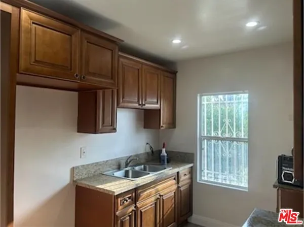 a kitchen with granite countertop a sink stove and cabinets