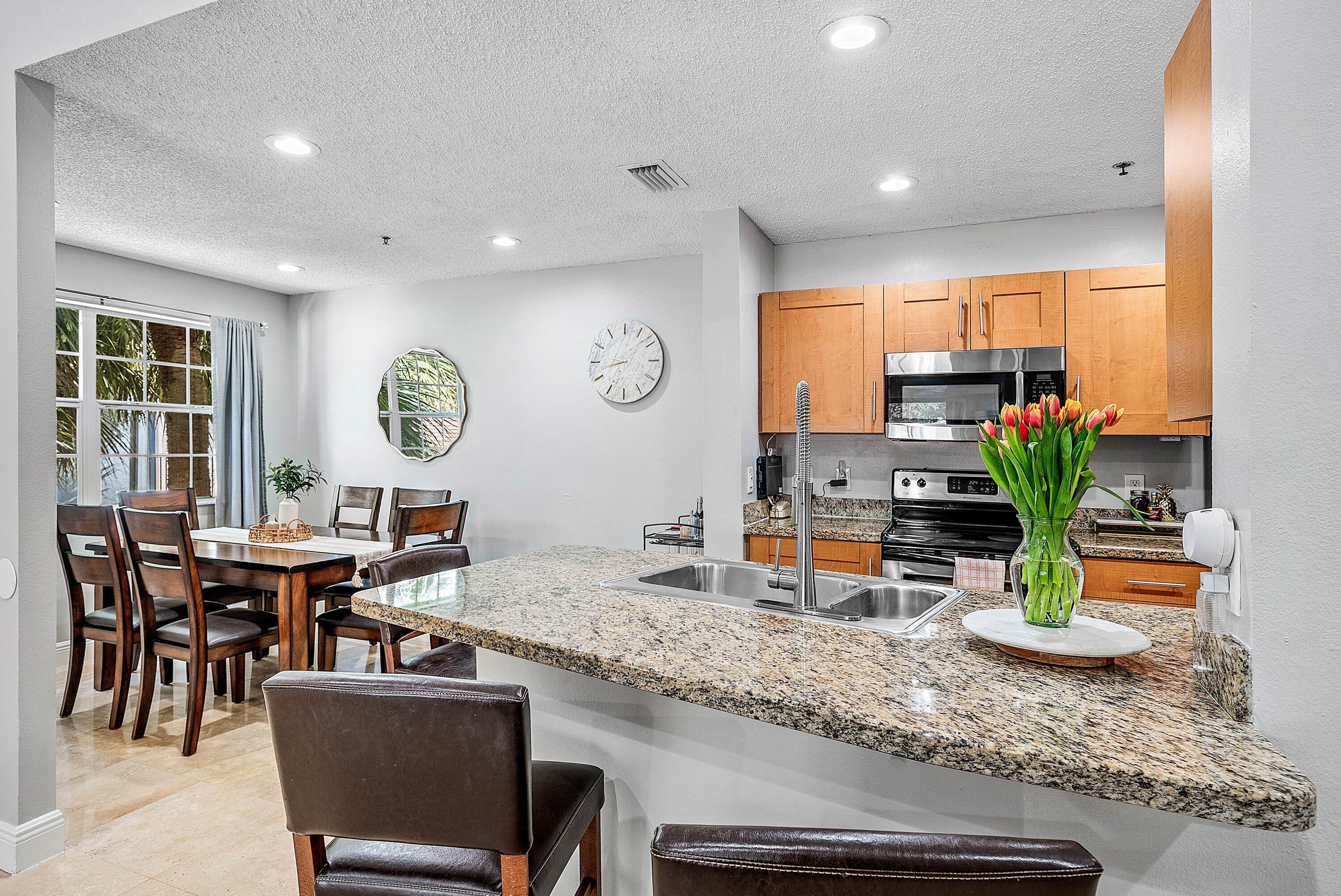 Undisclosed Address Boca Raton, FL 33496 - Photo 8 of 46 a view of a dining room and kitchen with a table and chairs