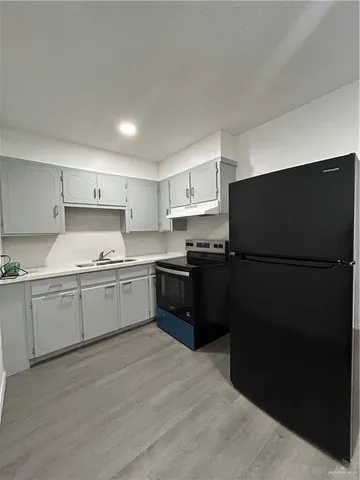 a kitchen with granite countertop a refrigerator and a sink