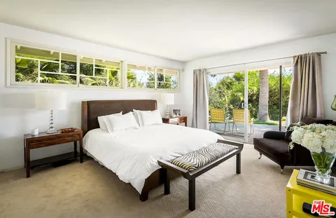 a bedroom with a bed and a couch next to a window