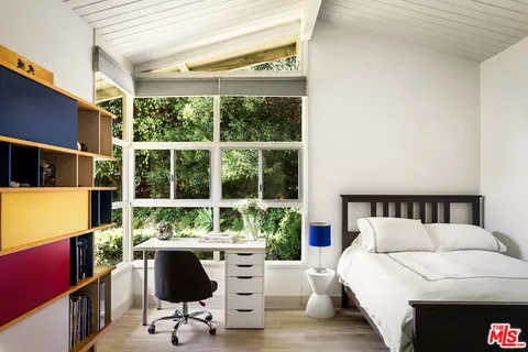 a living room with furniture a large window and a flat screen tv