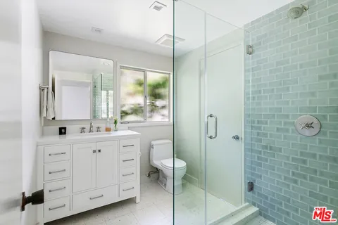 a bathroom with a double vanity sink toilet and shower