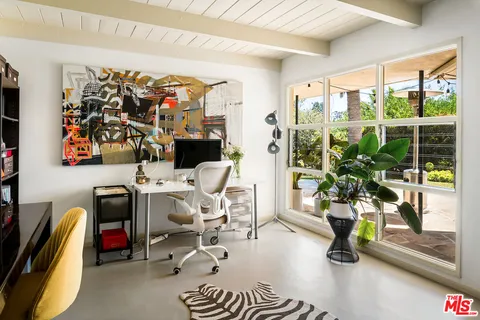 a living room with furniture gym equipment and a floor to ceiling window