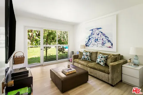 a living room with furniture and a floor to ceiling window