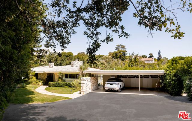 a view of a house with a yard and sitting area