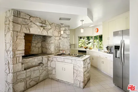 a kitchen with white cabinets and appliances