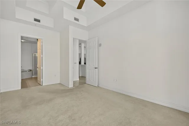 an empty room with chandelier fan