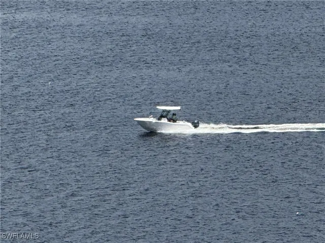 a living room with couches and kitchen view with wooden floor