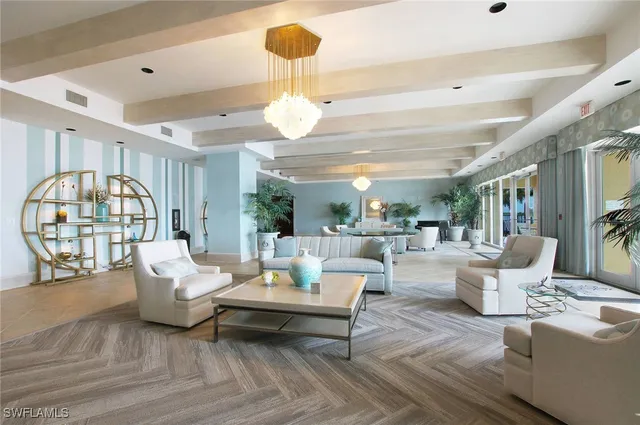 a living room with furniture a flat screen tv and kitchen view