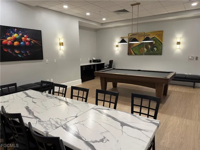 a room with pool table and windows