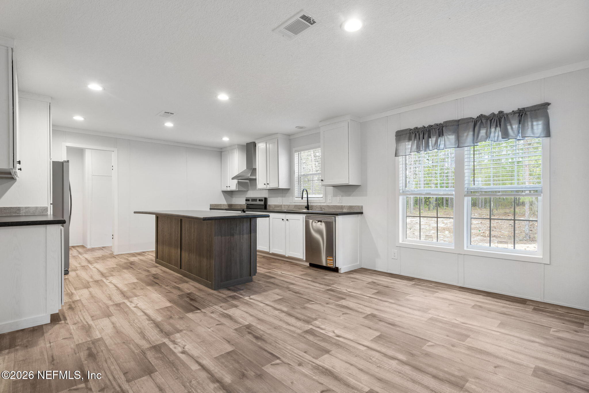 110 Slipper Way Hawthorne, FL 32640 - Photo 11 of 42 a kitchen with stainless steel appliances granite countertop a stove a sink a refrigerator white cabinets and wooden floor