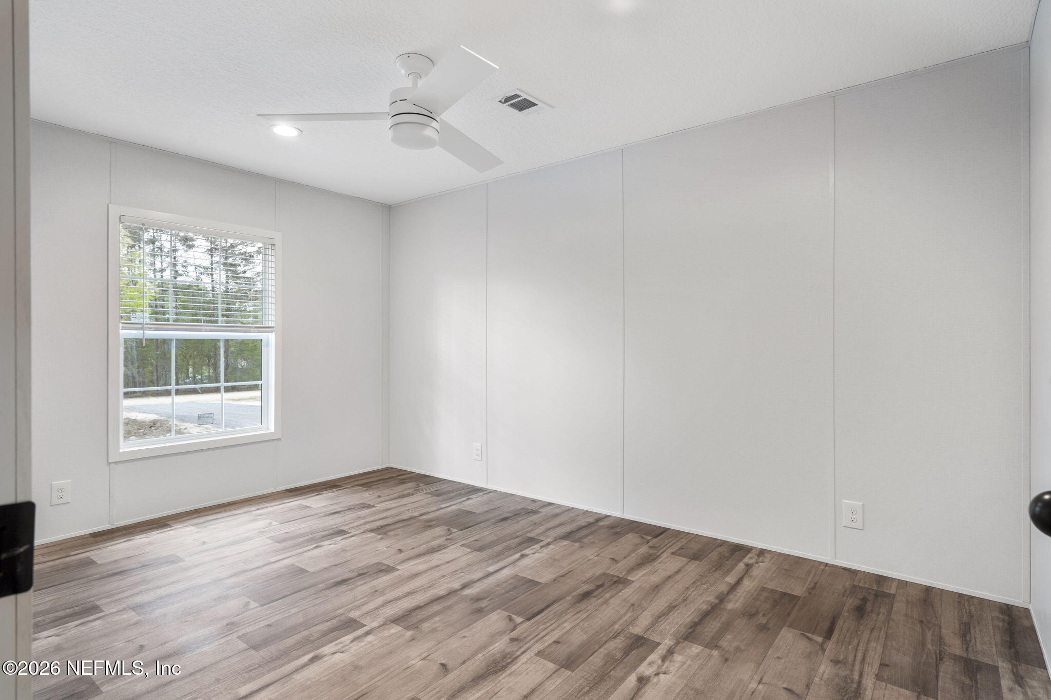 110 Slipper Way Hawthorne, FL 32640 - Photo 26 of 42 an empty room with wooden floor and windows